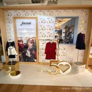 Vitrine événementielle des 50 ans de Jacadi aux Galeries Lafayette, décor or et blanc signé DELEAGE