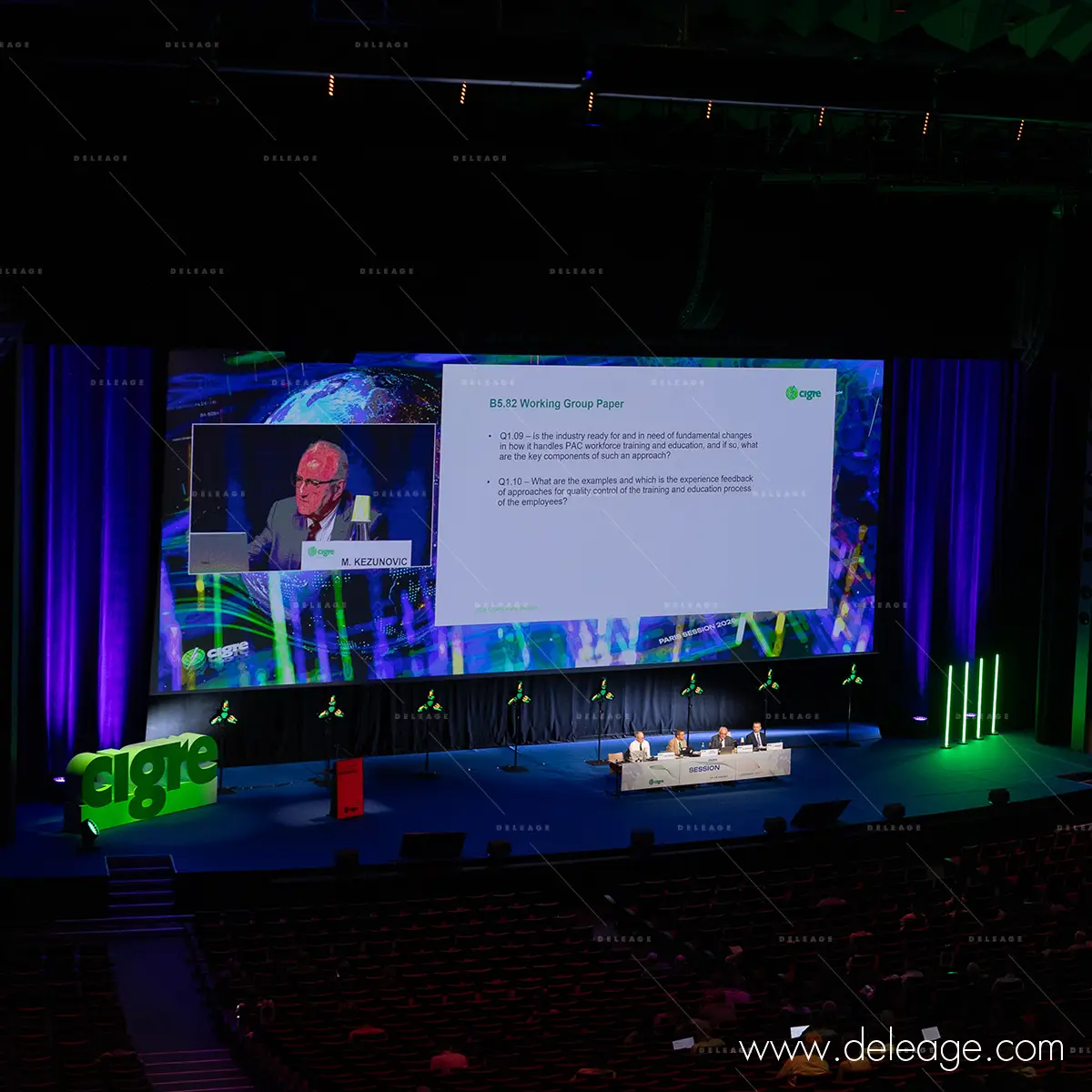 3-scene-pleniere-cigre-2026-logo-volume-deleage Scène plénière du CIGRE 2026 : grand écran de projection et logo en volume polystyrène en bord de scène